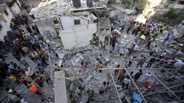 Rescue workers search for victims as Palestinians gather around the wreckage of a house in Rafah