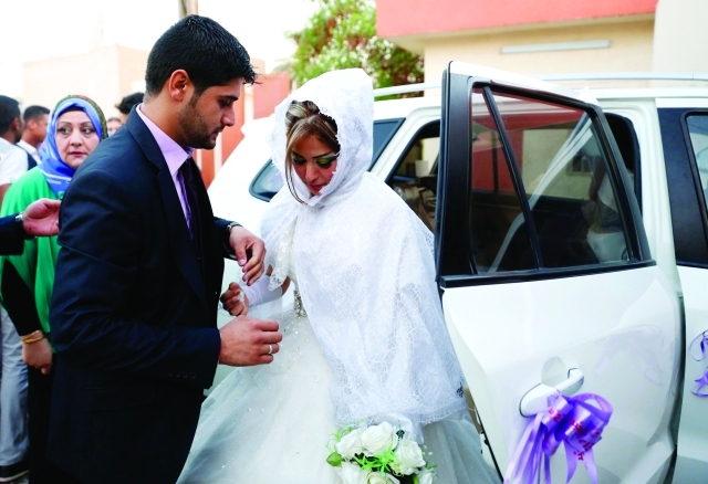 Displaced Iraqis who fled from the violence in Mosul walk during their wedding at a school in Baghdad