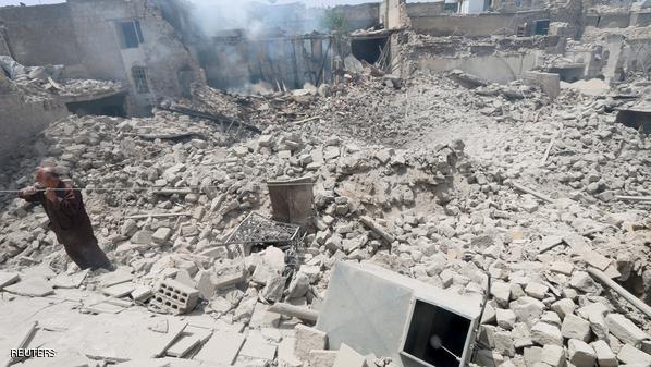 A man stands on rubble at a site hit by what activists said was a barrel bomb dropped by forces of Syria's President Bashar al-Assad in the Bab al-Nasr neighbourhood of Aleppo