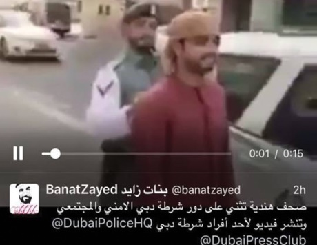 شرطي من دبي يساعد هندياً على لف العصامة الإماراتية