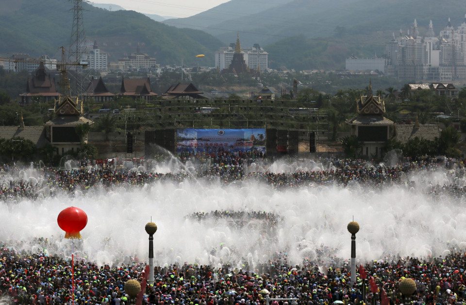 Visitors participate in the annual water-splashing festival in Xishuangbanna, Yunnan province, April 15, 2015. Thousands of people participated in the festival on Tuesday to celebrate the 1,377th ethnic Dai minority New Year, local media reported. REUTERS/Stringer CHINA OUT. NO COMMERCIAL OR EDITORIAL SALES IN CHINA. - RTR4XDSE