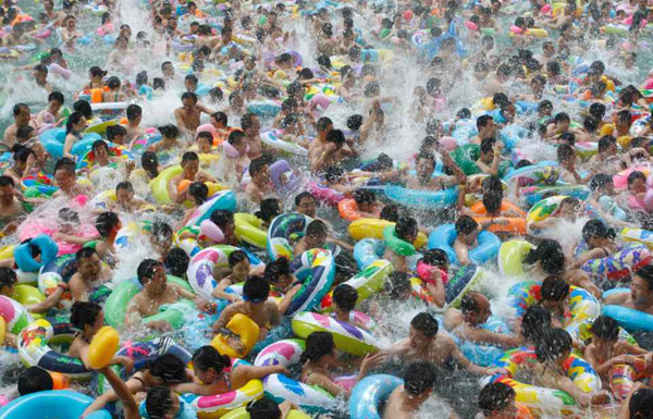 Residents crowd in a swimming pool to escape the summer heat during a hot weather spell in Daying county of Suining, Sichuan province July 4, 2010. China is experiencing temperatures over 35 degrees Celsius (95 degrees Farhenheit) in at least 13 provinces and regions, according to the National Meteorological Center on Sunday. Picture taken July 4, 2010. REUTERS/Stringer (CHINA - Tags: SOCIETY ENVIRONMENT IMAGES OF THE DAY) CHINA OUT. NO COMMERCIAL OR EDITORIAL SALES IN CHINA