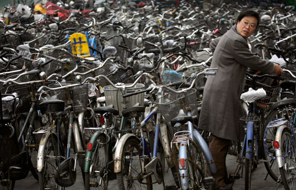 A woman collects her bicycle from a parking lot outside a subway station in Beijing in this November 12, 2007 file photo. Rising petrol prices, growing awareness of environmental issues and the popularity of cycling as a recreation sport has spurred a surge in demand for bicycles around the world and Taiwan, home of some of the world's biggest bike manufacturers, is reaping the profits. To match feature BIKES-TAIWAN/ REUTERS/Reinhard Krause/Files (CHINA) - RTX5NU5