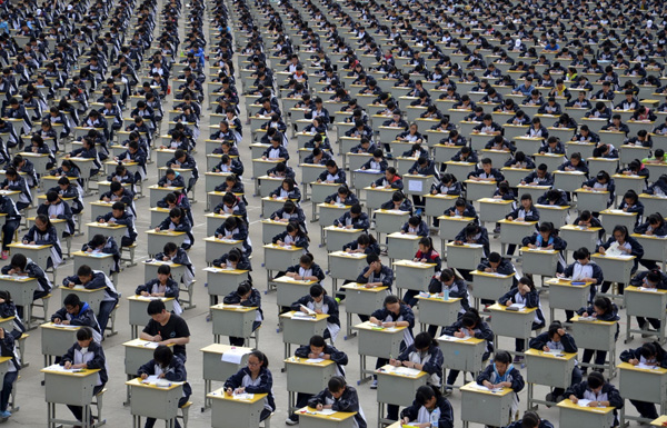 Students take an examination on an open-air playground at a high school in Yichuan, Shaanxi province April 11, 2015. More than 1,700 freshmen students took part in the exam on Saturday, which was the first attempt by the school to take it in open-air. The school said the reasons was due to the insufficient indoor space and also that it could be a test of the students' organizing capacity, local media reported. Picture taken April 11, 2015. REUTERS/Stringer TPX IMAGES OF THE DAY - RTR4WYSJ